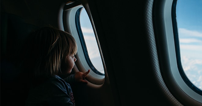 child sitting on plane looking out the window